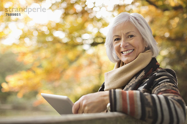 Ältere Frau mit Tablet-Computer im Freien