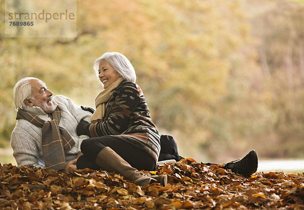 Älteres Paar im Herbstlaub sitzend