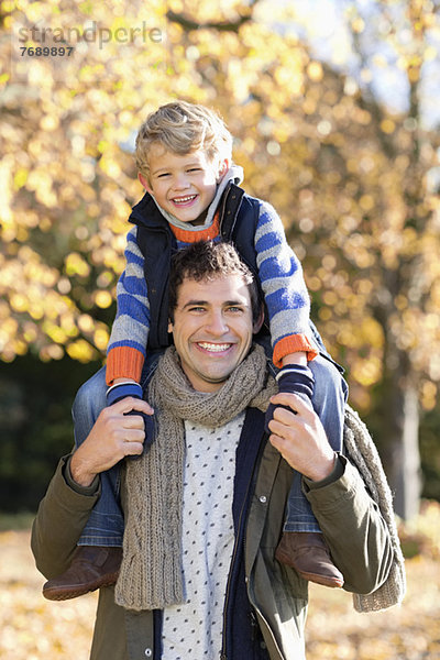 Mann mit Sohn auf den Schultern im Park