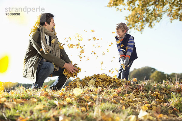 Vater und Sohn spielen im Herbstlaub