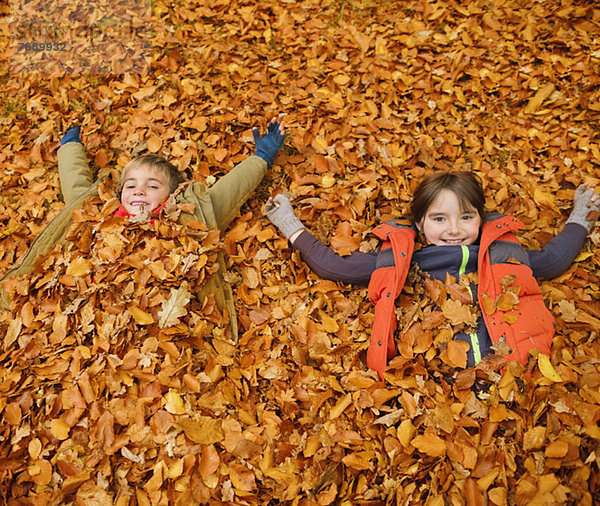 Kinder legen im Herbstlaub