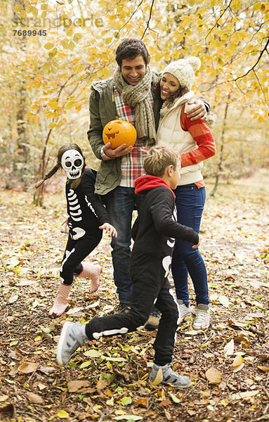 Paar mit Kindern in Skelettkostümen im Park