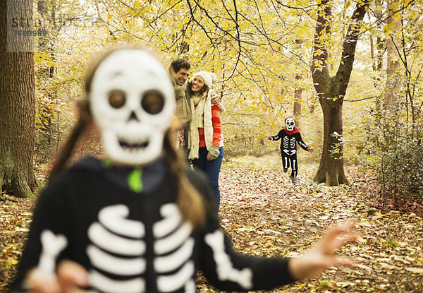 Kinder in Skelettkostümen spielen im Park