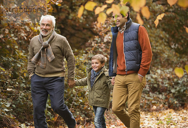 Drei Generationen von Männern  die im Park spazieren gehen.
