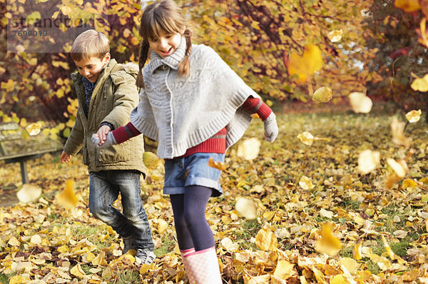 Kinder spielen im Herbstlaub