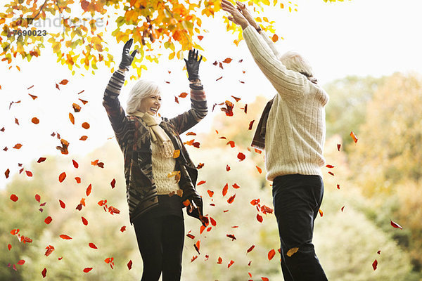 Älteres Paar spielt im Herbstlaub