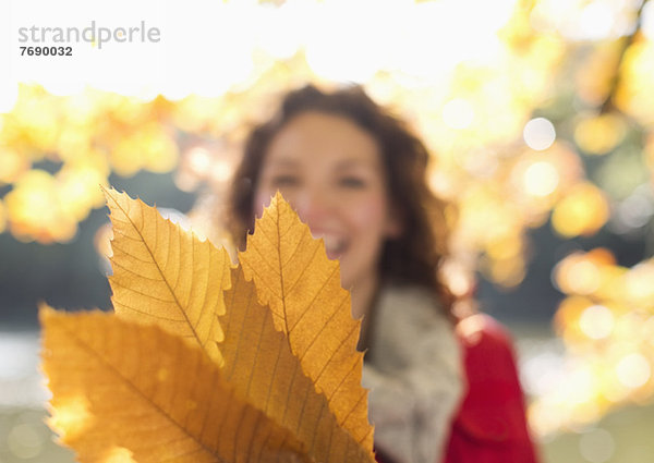 Frau mit Herbstlaub im Park