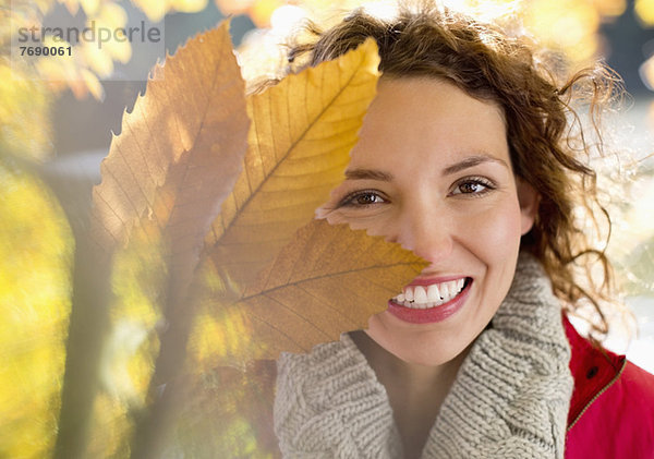 Frau spielt mit Herbstblättern