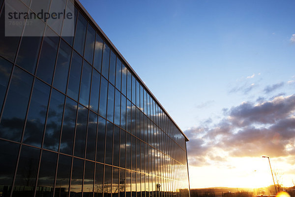 Sonnenaufgangshimmel im Spiegel moderner Gebäudefenster