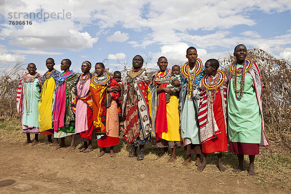 Traditionell geschmückte Massai-Frauen in volkstümlicher Kleidung bei einer Gesangsvorführung