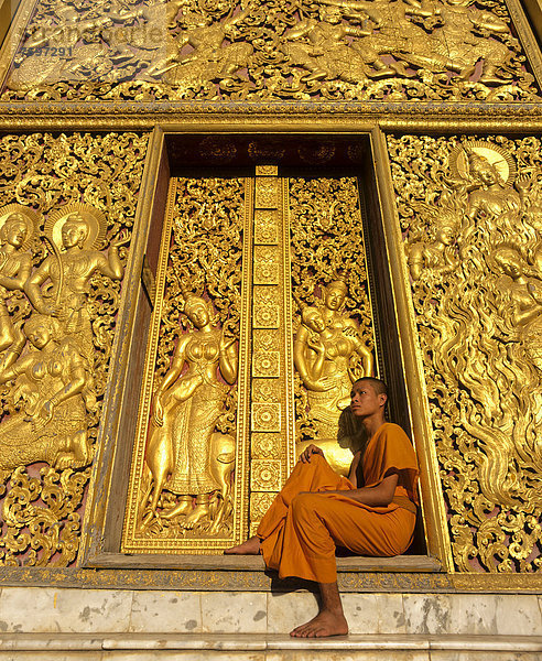 Goldene Reliefs  Mönch am Eingang zum Carriage House  Wat Xieng Tong oder Vat Xienthong