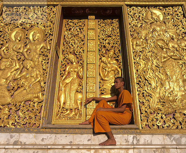 Goldene Reliefs  Mönch am Eingang zum Carriage House  Wat Xieng Tong oder Vat Xienthong