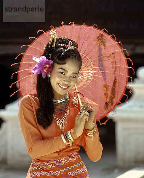 Junge Frau in traditionellem Seidengewand  mit Papierschirm