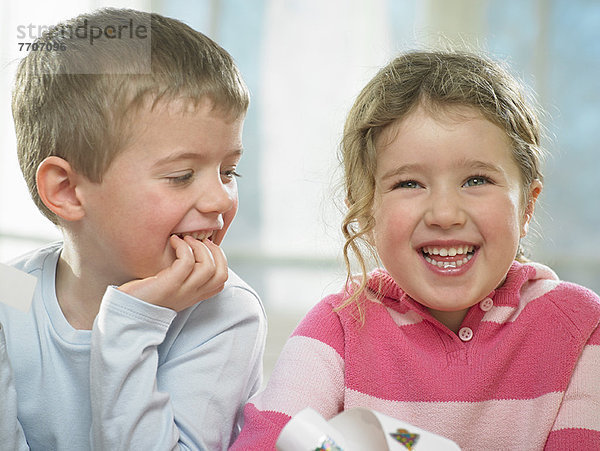 Kinder beim gemeinsamen Lachen im Haus