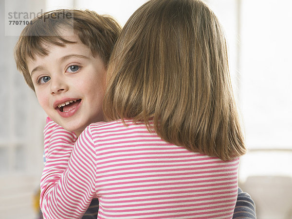 Mädchen flüstert ins Ohr der Jungen