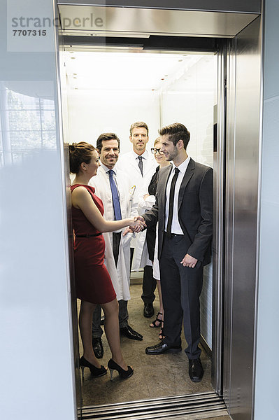 Ärzte und Geschäftsleute im Aufzug