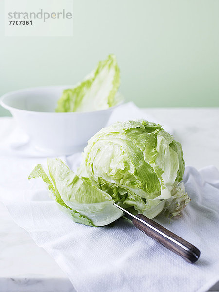 Messer durch den Salatkopf schneiden