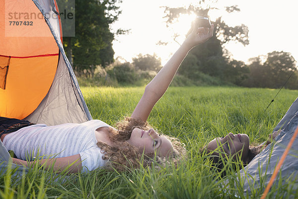 Jugendliche Mädchen beim Fotografieren auf dem Campingplatz