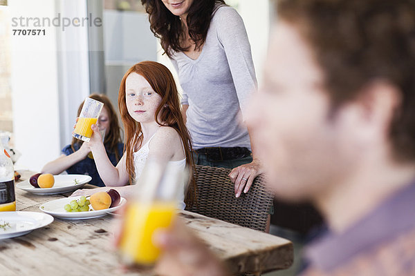 Mädchen beobachtet Vater trinken Orangensaft