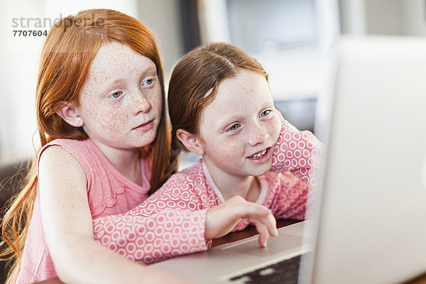 Mädchen  die gemeinsam einen Laptop benutzen