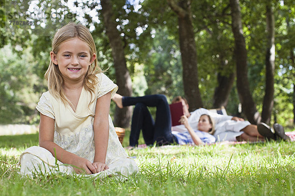 Mädchen im Park im Gras sitzend