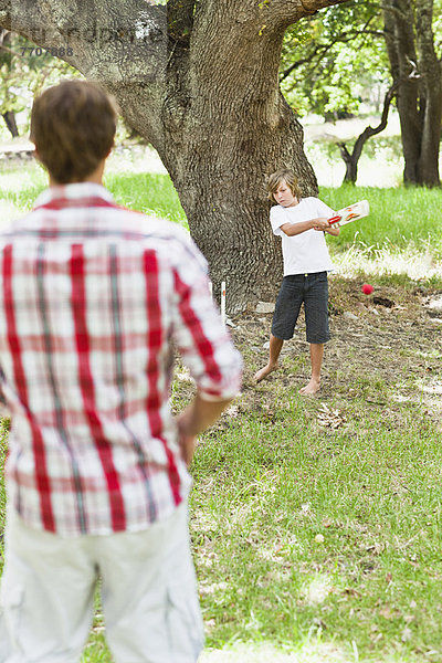 Vater und Sohn spielen im Park