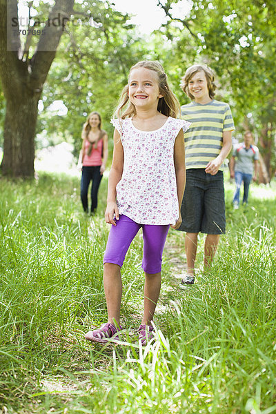 Kinder beim gemeinsamen Spaziergang im Gras