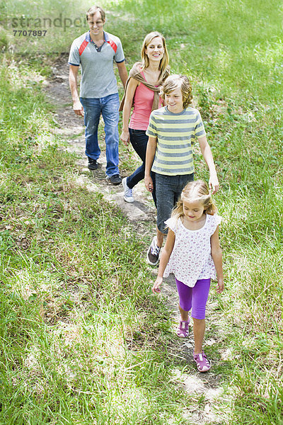 Familie beim gemeinsamen Spaziergang im Gras