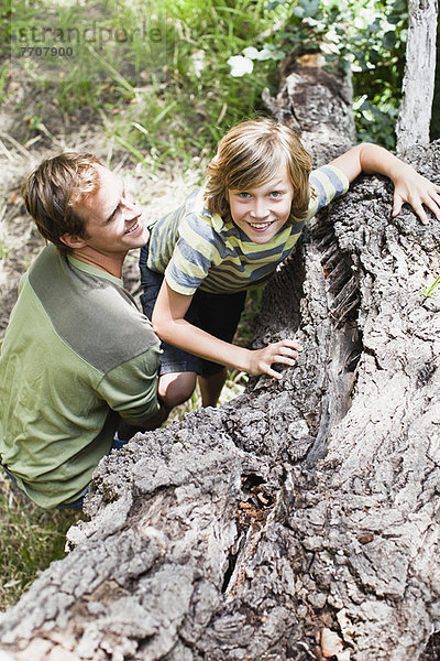 Vater hilft Sohn über umgestürztem Baum