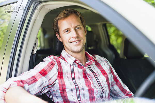 Lächelnder Mann im Auto sitzend