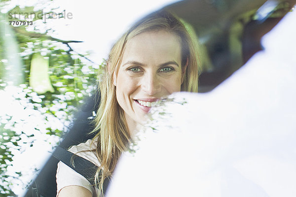 Lächelnde Frau im Auto sitzend