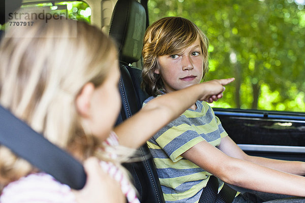 Kinder sitzen auf dem Rücksitz des Autos