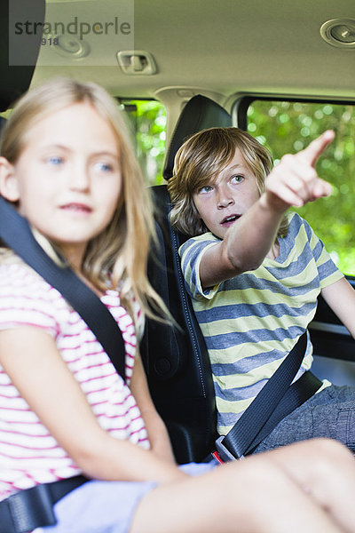 Kinder sitzen auf dem Rücksitz des Autos