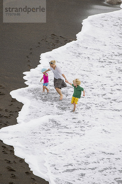 Mutter und Kinder beim Wellenreiten