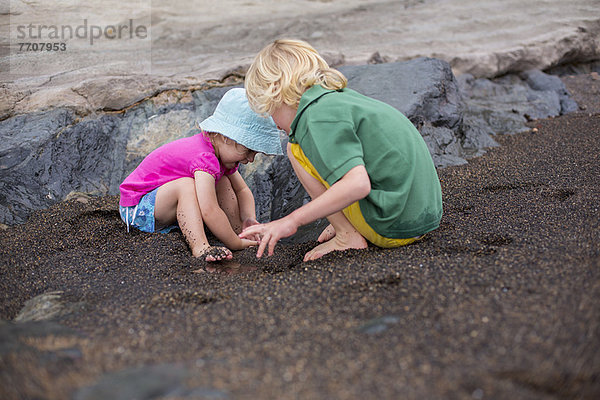 Kinder spielen im Sand am Strand