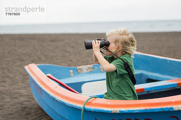 Junge mit Fernglas am Strand