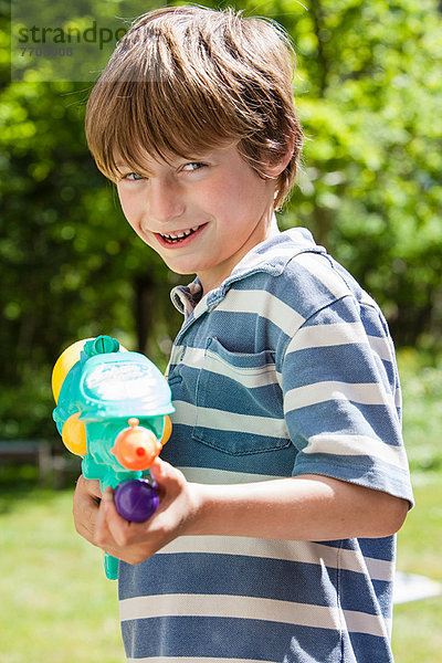 Junge mit Wasserpistole im Freien