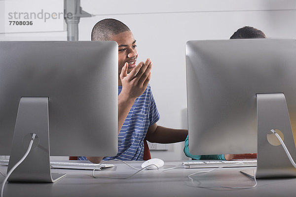 Kinder  die Computer am Schreibtisch benutzen