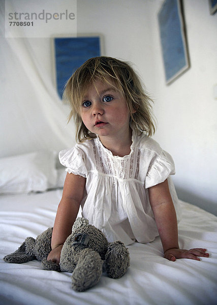 Mädchen mit Teddybär im Bett