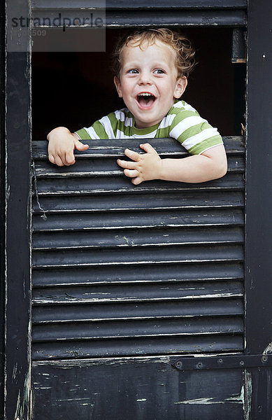 Kleinkind Junge  der aus dem Fenster schaut.