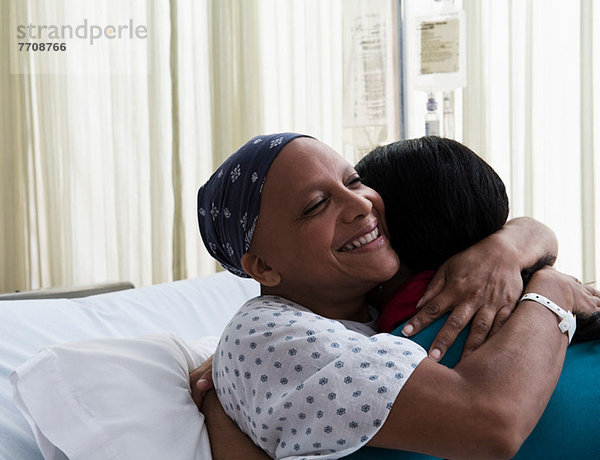 Tochter umarmt Mutter im Krankenhaus