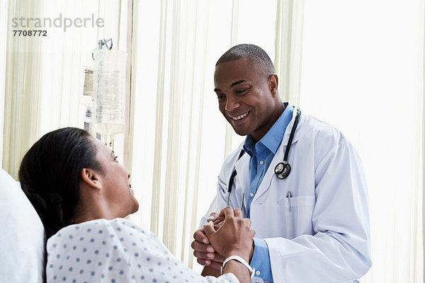 Arzt hält Händchen mit dem Patienten