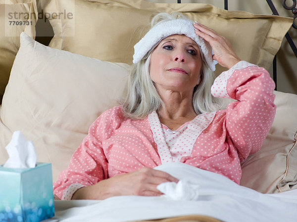 Kranke ältere Frau im Bett liegend