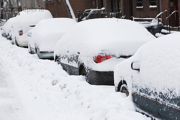 Schneebedeckte Autos auf der Stadtstraße