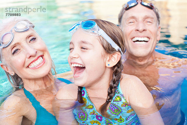 Mädchen und Großeltern schwimmen im Pool