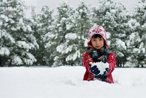 Junge mit Schneeball im Freien
