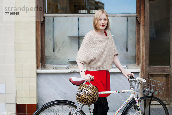 Frau geht mit dem Fahrrad durch die Stadt