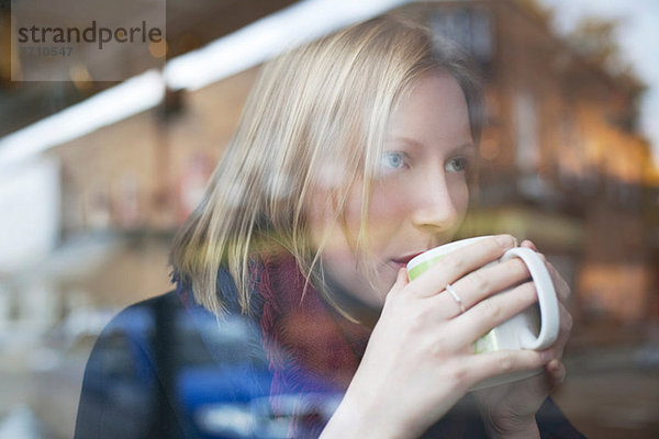 Frau trinkt eine Tasse Kaffee im Café