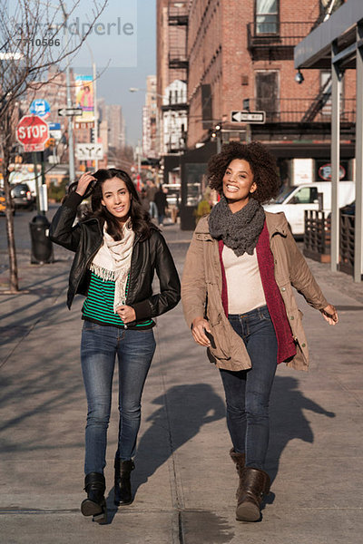 Frauen  die zusammen auf der Stadtstraße spazieren gehen