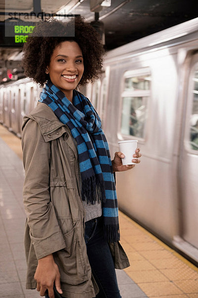 Frau beim Kaffee in der U-Bahn-Station